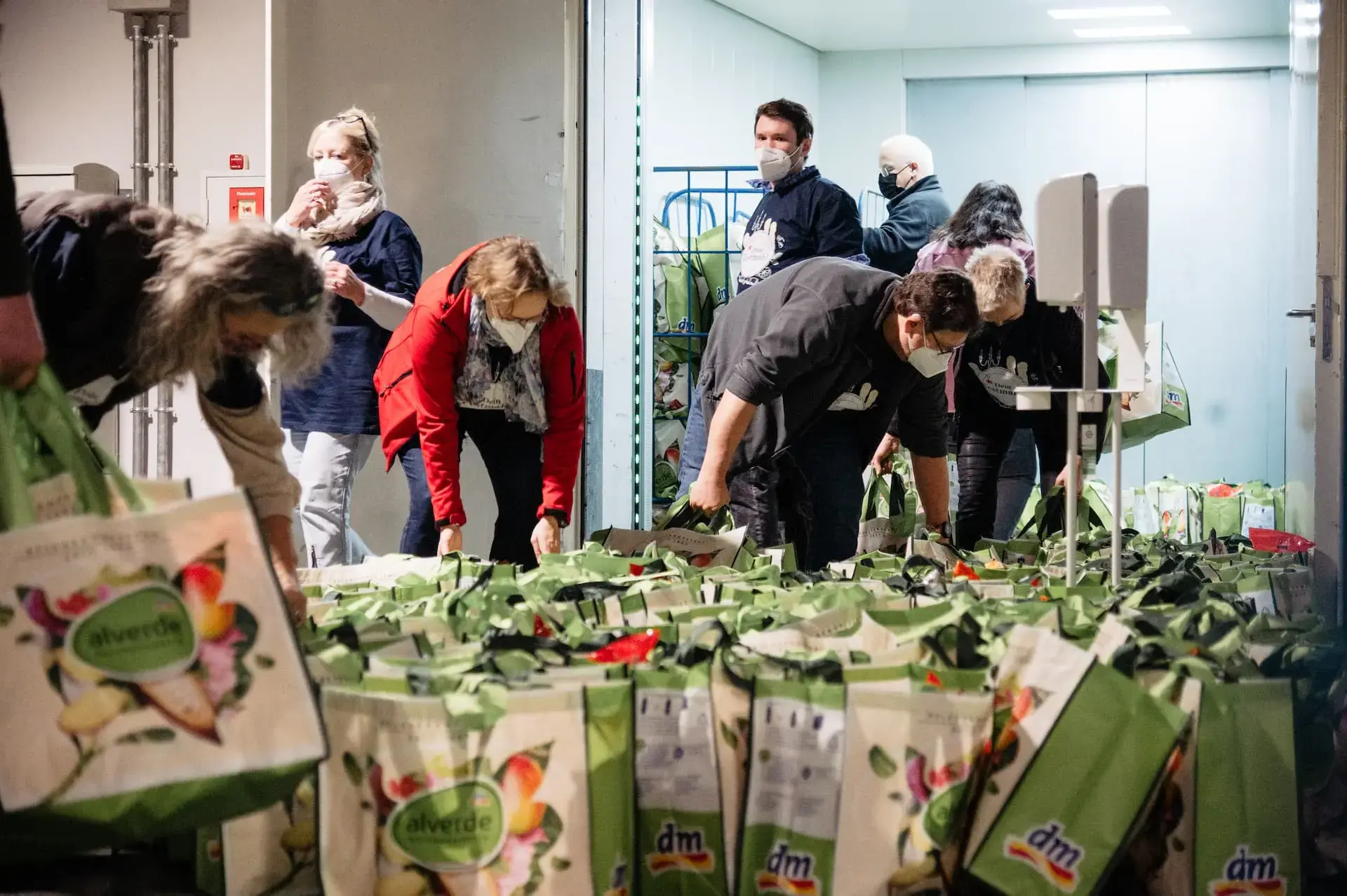 Ehrenamtliche packen gemeinsam Tüten für die Gäste.